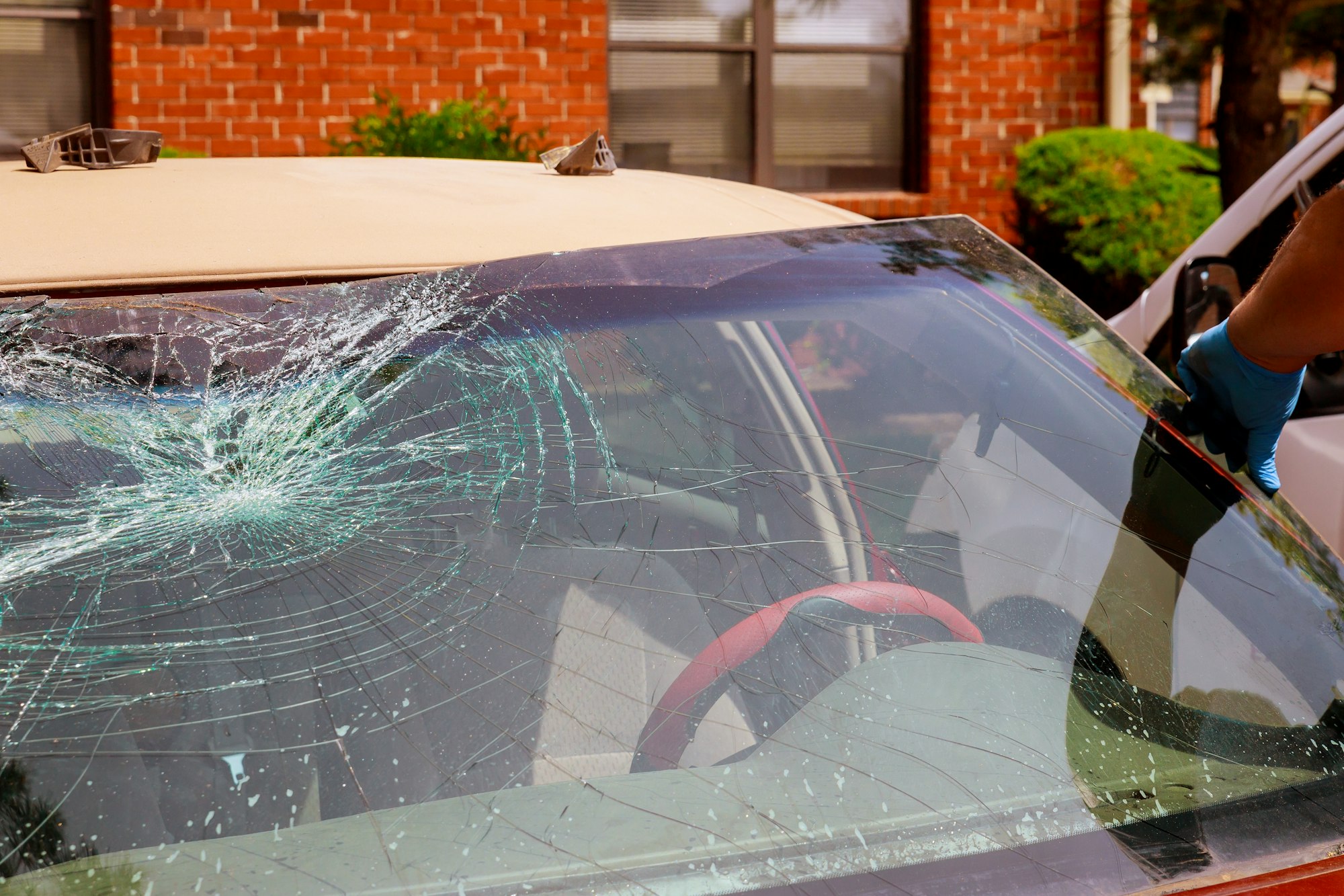 Special workers remove broken windshield of a car in auto service station